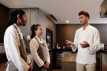 Fototapeta na wymiar Restaurant chef talking to his team before starting new shift