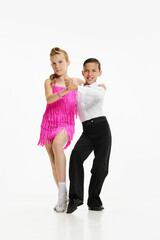Beautiful, stylish children boy and girl dancing retro style dance, performing against white studio...