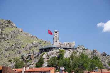 Gonul Mountain in Eskişehir Sivrihisar Old stone clock tower and Turkish flag among blue sky and stones. Gonul Dagi Sivrihisar