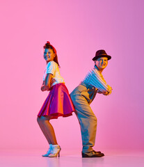 Stylish children, boy and girl on retro style clothes posing with emotive face, facing against pink...