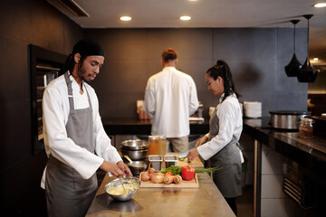 Team of great professionals working in modern kitchen of fancy restaurant