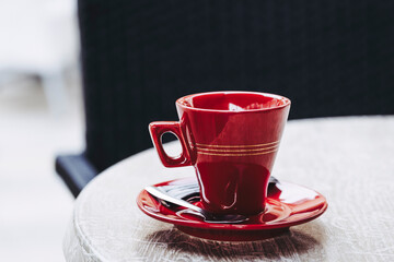 Tasse à café en porcelaine rouge posée sur une table