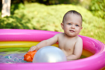cute baby girl swimming in kid inflatable pool