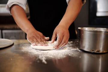Obraz na płótnie Canvas Closeup image of baker kneading small piece of dough