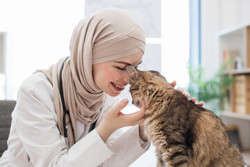 Vet in hijab fondling furry patient in exam room of clinic
