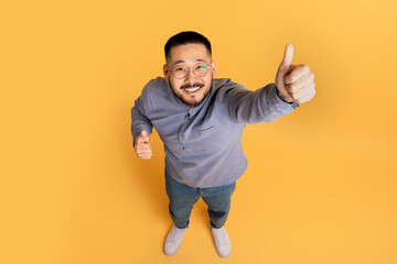Above Shot Of Cheerful Asian Man Showing Thumbs Up At Camera