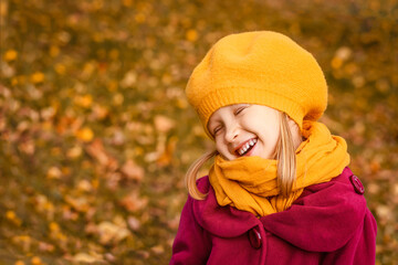 Autumn Child in Autumn Fashion Clothes in Autumn Background. Happy Kid Having Fun in Yellow Autumn Nature. Little Girl Kid Portrait on Fallen Leaves.  