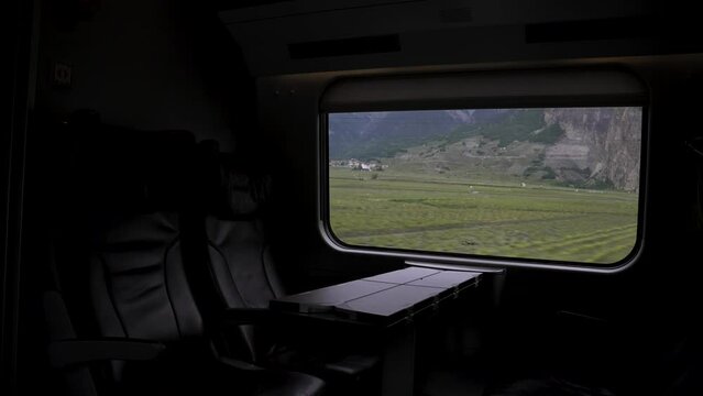 Dark Interior View Of Empty Leather business class seats travelling through Switzerland with train through scenic landscapes. Slow Motion Shot