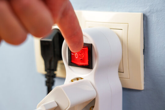 Turning off the red button of the electrical splitter to save electricity