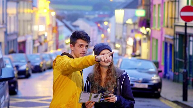 Young couple looking at a map in the town of Dingle in Ireland - travel Ireland photography clip 