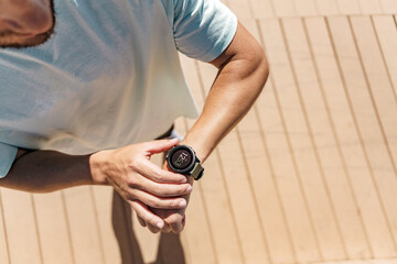 The top view of the screen uses a fitness bracelet for a cardio trainer athlete measured in the app. Training outside in sportswear. Healthy lifestyle.