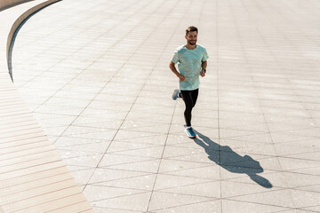 An athlete, a running sports man, a male coach, a runner in sports shoes. A male trainer in fitness...