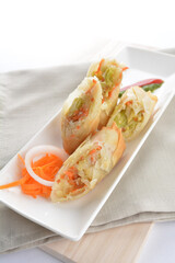 deep fried vegetable spring roll in long plate snack on white background asian chef appetiser halal bakery food restaurant pastry menu for cafe