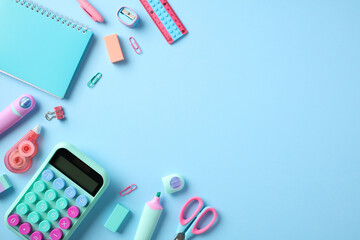 Back to school concept. School supplies on pastel blue background. Flat lay composition with calculator, paper notebook, scissors, pencils, pens, sharpeners, erasers