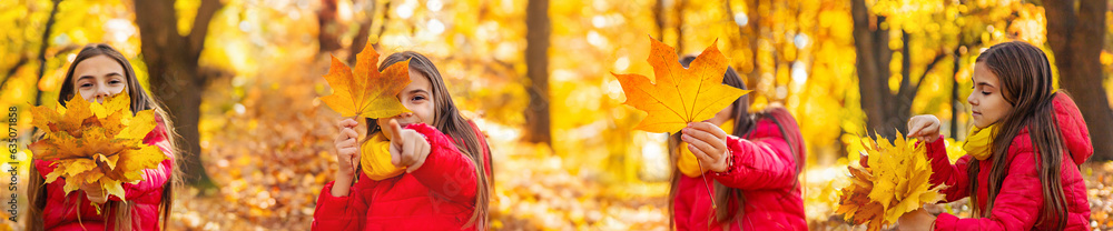 Wall mural Autumn child in the park with yellow leaves. Selective focus.