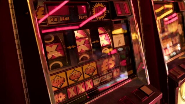 Amusements, gaming machine. Slot machine spinning noughts and crosses. Gambling. Filmed East Yorkshire
