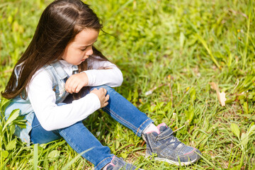 Beautiful sad little girl crying, on summer background.