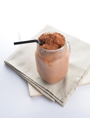 cold iced chocolate milk milo dinosaur with coco powder in glass black straw on grey cloth white background asian beverage halal food drink menu for hotel bar