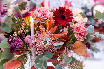 Obraz na płótnie Canvas Festive table setting with basket of autumn flowers, candle