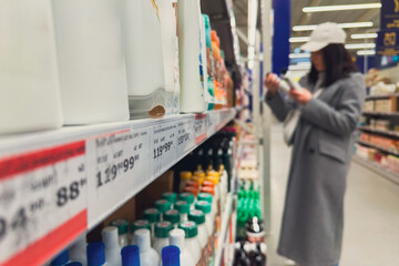 woman in groceries store choosing shampoo