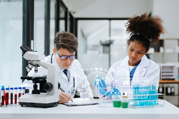 Focused mature male doctor and African female nurse look at tablet and laptop screen discuss anamnesis together. Concentrated diverse medical professionals
