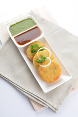 Indian deep fried round potato snack hash brown with green yogurt and red chilli sauce breakfast on white background asian chef appetiser halal bakery food restaurant pastry menu for cafe