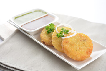 Indian deep fried round potato snack hash brown with green yogurt and red chilli sauce breakfast on white background asian chef appetiser halal bakery food restaurant pastry menu for cafe