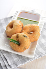 Indian vegetable deep fried mini donut bread in green yogurt and red chilli sauce breakfast on white background asian chef appetiser halal bakery food restaurant pastry menu for cafe