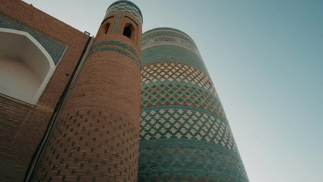 Ancient architecture of city of Khiva. Uzbekistan. Kalta Minor Minaret at Sunset. Medieval oriental architecture, central Asia. Silk road. Popular travel destination. Old islamic town
