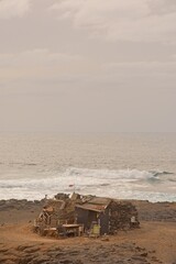 Obraz premium Lonely abandoned old house on the coast against sea in El Confital, Las Palmas de Gran Canaria, Spain