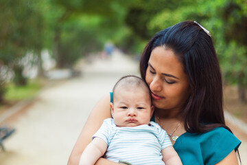 Young woman tenderly gazing at her newborn baby