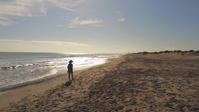 Seaside Soar: Drone Captures Woman's Tranquil Beach Walk