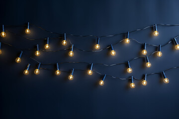 Christmas garland on a dark blue wall, festive minimalist background