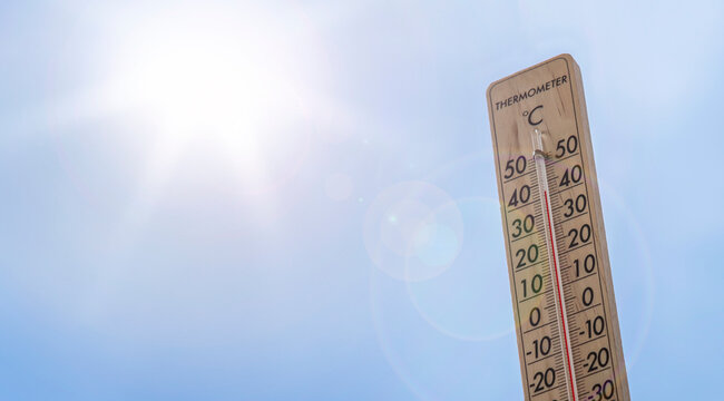 Blue sky, strong sun and thermometer showing high 