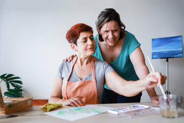 Artist senior gay couple painting with watercolor at home workshop - Lesbian family, LGBTQ concept
