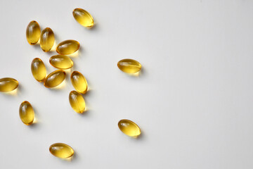 Yellow tablets, capsules, vitamins on a light gray background, medical background