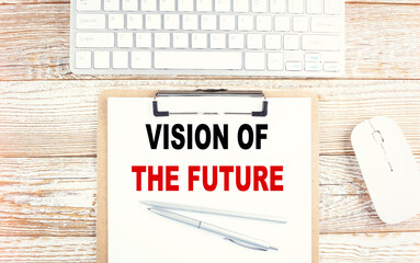VISION OF THE FUTURE text on a clipboard with keyboard on wooden background