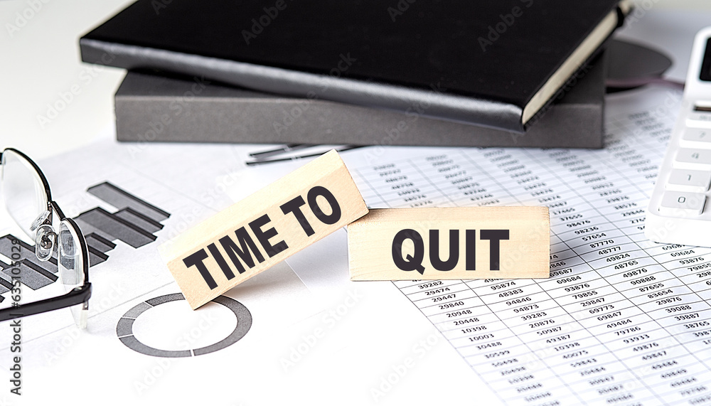 Poster time to quit - text on a wooden block with chart and notebook