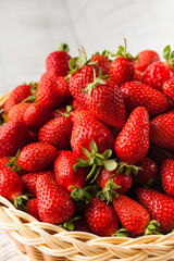 A basket with ripe juicy strawberries on a wooden table. Berries, harvesting.
