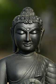 Black stone Buddha statue in India - black background