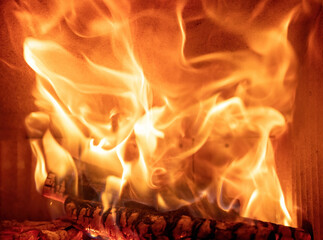 Fire flames and burning wood logs, fireplace close up,