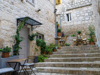 Fototapeta na wymiar Charming corner with arranged tables in the middle of historic town of Hvar