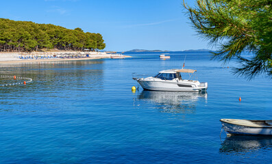 Fototapeta na wymiar Beach and boats on the Adriatic coast. Primosten, Croatia.