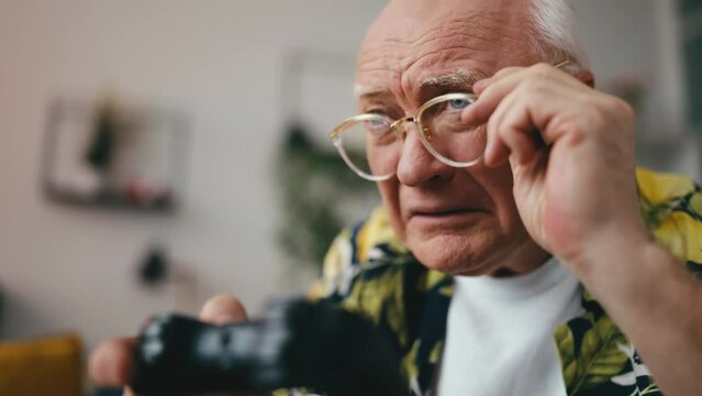 Closeup of funny senior man holding joystick, playing addictive game, having fun