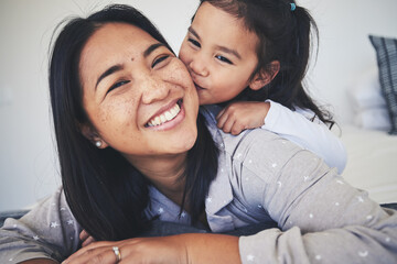 Kiss, mother and daughter in bed at home with love, care and happiness in morning. Portrait of a woman and girl child together in a bedroom for fun time, playing and security or relax in family house