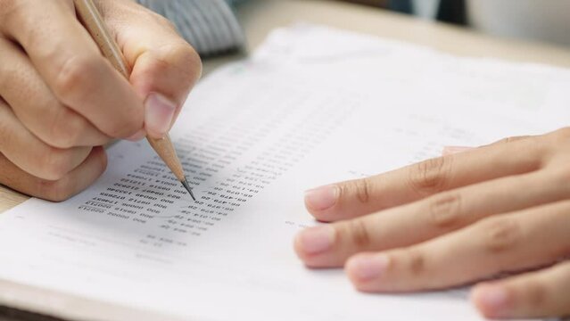 Accounting and Financial PlanningHand of Asian Woman analyzing business marketing data on paper dashboard at office table. Investment Analysis