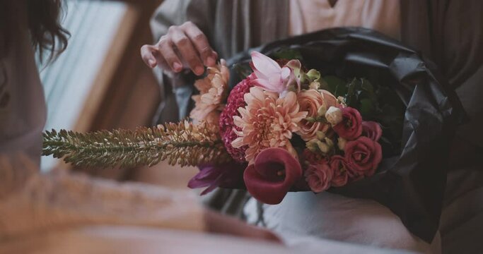 Flowers being touched gently by a newlywed queer couple