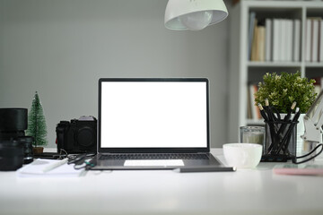 Empty screen of laptop computer on photography workspace.