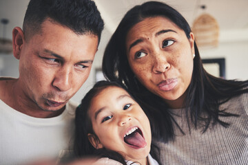 Selfie, silly and portrait of girl with her parents bonding in the living room of their home. Goofy, happy and child taking a picture with her mother and father with funny faces at their family house