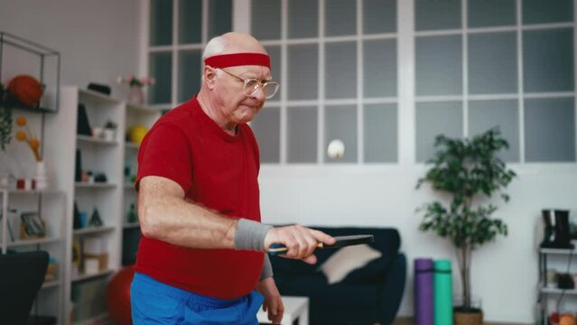 Funny senior man bouncing ping pong ball on a racket, retirement hobby, sports